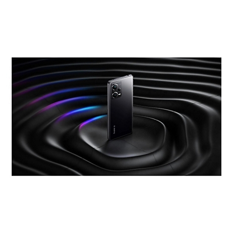 Schwarzes Smartphone auf wellenförmigen, glänzenden Untergrund. Lichtreflexe in Blau und Violett. Aufschrift "Redmi".