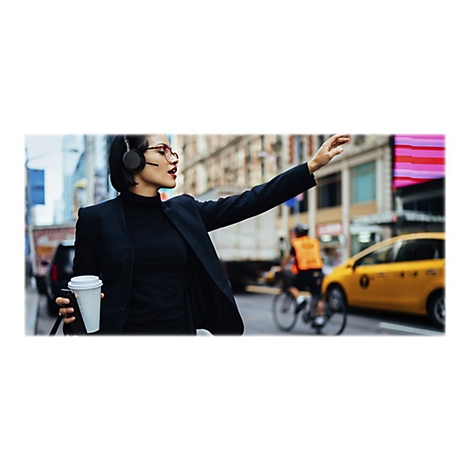 GeschÃ¤ftsfrau in New York winkt nach einem Taxi. Sie trÃ¤gt KopfhÃ¶rer und hÃ¤lt einen Kaffeebecher.