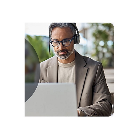 Ein Mann mit Brille und Headset sitzt am Laptop. Er trÃ¤gt ein Jackett.
