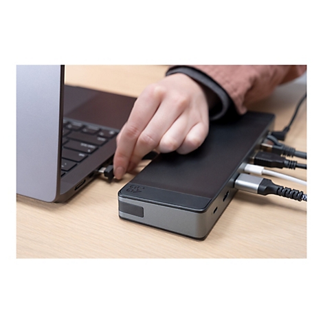 Main branchée à un hub USB connecté à un ordinateur portable. D'autres câbles sont branchés sur le hub.