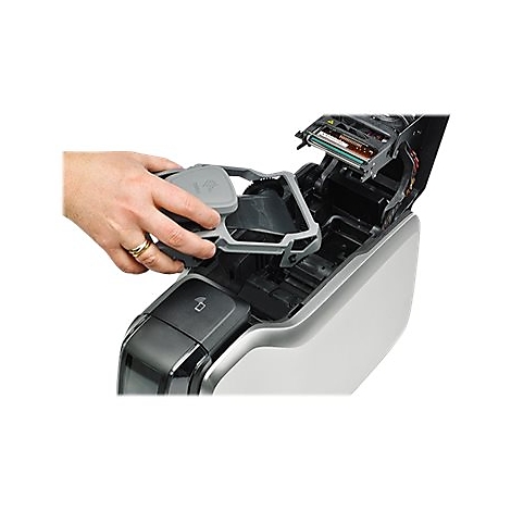 Eine Hand hÃ¤lt einen grauen Rahmen, der in ein GerÃ¤t eingesetzt wird. Das GerÃ¤t ist offen und zeigt Details.