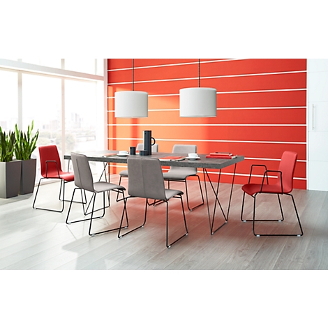 Dining room with table, chairs, lamps in front of red wall.