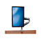 Ein Monitor mit Halterung steht auf einem Holztisch. Der Bildschirm zeigt einen blauen Farbverlauf.