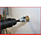 Bohrmaschine bohrt in eine Wand. Bohrer in der Wand, Metallmanschette am Bohrer.