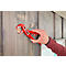 Person holding a red clamp against wooden slats. The clamp fixes a wooden dowel.