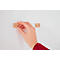 A hand is holding a wooden frame with a screw against a white wall. A second frame is already attached.
