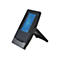 Schwarzes Touchscreen-Telefon mit blauem Display auf einem Standfuß vor weißem Hintergrund.