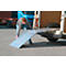 Person opening a loading ramp on a white van. A blue truck cabin can be seen in the background.
