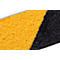 Close-up of an anti-slip surface, with a diagonal cut in yellow and black.