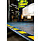 Worker transporting goods on a pallet. Yellow and black markings on a ramp.