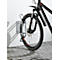 Una bicicleta de montaña negra en un soporte de pared. La rueda delantera de la bicicleta es visible.