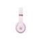 Casque Beats rose clair en détail sur fond blanc. L'arceau a une application dorée avec le chiffre 4. Le logo Beats est visible sur l'écouteur.