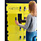 Jeune femme ouvrant un casier jaune. Sur le casier, il est écrit "CHARGING LOCKERS". Elle tient un objet noir.