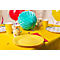 Table jaune avec ballons, assiettes, tasses et décoration. Tout pour une fête.