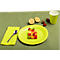 Assiette avec des fruits coupés en dés colorés, du citron, des fraises, une serviette, une cuillère et une tasse sur un fond vert.