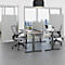 Ein Büro mit grauen Schreibtischen, Bürostühlen, Raumteilern und Fenstern mit Stadtblick.