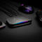 AVerMedia Capture Card mit RGB-Lichtstreifen auf einem Schreibtisch neben Gaming-Maus und Controller.