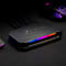 Schwarze AVerMedia Capture Card mit RGB-Beleuchtung auf einem dunklen Tisch, angeschlossene Kabel sichtbar.