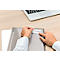 A person is sticking a label that says "PRIME CORE" onto a gray folder. A laptop is in the background.