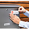 Hands sticking a "No advertising" sign on a metal mailbox. The sign says "STOP" and other instructions.