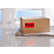 Two wine glasses stand next to a package with the red sticker "Fragile!" in German.