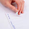 Hand die een wit zelfklevend polsbandje van een A4-vel lostrekt.