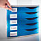 Blue desk organizer with drawers labeled 'Inbox', 'Controlling', 'Sales', 'Budget' and 'Marketing'. A hand is attaching a label.