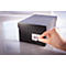 A hand is applying a barcode sticker to a black box.