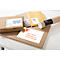 Various packages and envelopes, labeled with address labels, are lying on a white surface.
