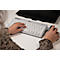 Person bedient Tastatur und Maus an einem Schreibtisch. Der Monitor ist im Hintergrund.