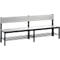 Grey bench with black frame and backrest. Below the seat are bars for shoe storage.