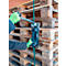 Persoon met groene handschoenen spant een band rond pallets met een blauw gereedschap. Op de achtergrond meer pallets.