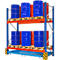 Magazijnrek met blauwe en rode vaten op pallets.