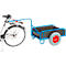 Bicycle with blue trailer. The trailer has a black loading area and a gray wheel with a red hub. The bicycle is partially visible.