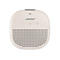Beiger, quadratischer Bose Bluetooth-Lautsprecher mit abgerundeten Ecken und zentralem Logo vor weißem Hintergrund.