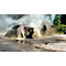 Zwei Feuerwehrleute löschen mit Schläuchen einen Brand unter einer Plane. Rauch steigt auf. Ein dritter Feuerwehrmann steht daneben.