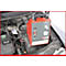 Ein rotes, graues Gerät zur Druckregulierung im Motorraum eines Autos.