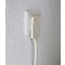 Prise de courant avec adaptateur branché et câble sur mur blanc.