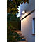 Buitenmuur met licht, trap en groene planten. De muur wordt verlicht door een spot.
