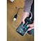 Gros plan : personne tenant un smartphone, le chargeant. Chargeur et câble sur plancher en bois.