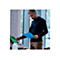 Ein Mann legt blaue Dokumente in einen Scanner, während er braune Hosen und ein dunkelblaues Hemd trägt.