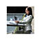 Eine Frau in einem grauen Blazer sitzt an einem Tisch und bedient einen mobilen Scanner. Auf dem Tisch liegt ein Laptop.