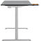 Bureau réglable en hauteur avec plateau gris et cadre clair. Un tiroir est ouvert.