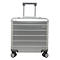 Valise argentée avec poignée extensible et roues sur fond blanc.