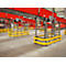 Industrial hall with conveyor belts. Red conveyor belts above yellow protective devices, concrete floor.