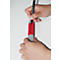 Person writing on a red sticker with a black pen. The sticker says "DRUCKER".