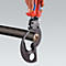 Hand holding cable cutter. The cutter surrounds a black cable, whose interior is exposed with copper conductors.