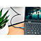 Un ordinateur portable avec un câble d'alimentation, un moniteur, une plante et une surface en bois. Un paysage naturel est visible dans l'ordinateur portable.