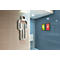 Panneau de toilettes pour hommes en métal sur un mur carrelé beige à côté d'un espace intérieur bleu.