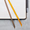 Carnet avec couverture marron et deux marque-pages colorés, jaune et marron. À côté, un stylo.